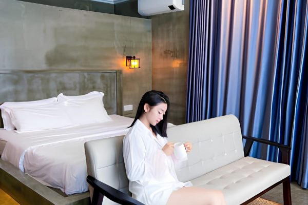 Woman sits on couch in boutique villa at damnak borey resort in kampot