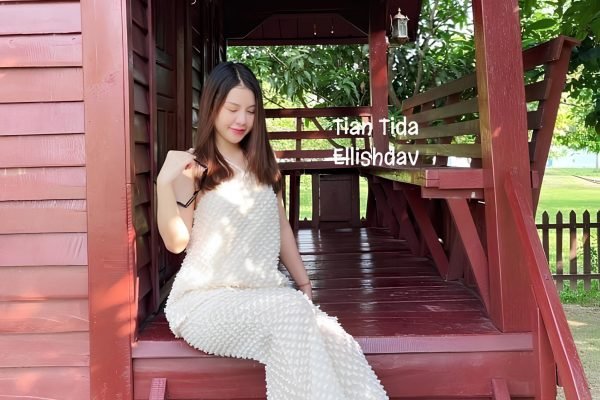Woman sitting at private balcony at wooden house at damnak borey resort
