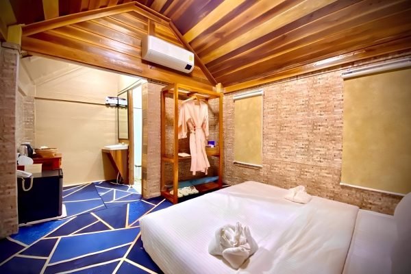 Wooden House inside bed view at bath robe at Damnak Borey Resort in kampot